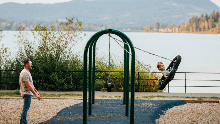 Child on swing with lake background
