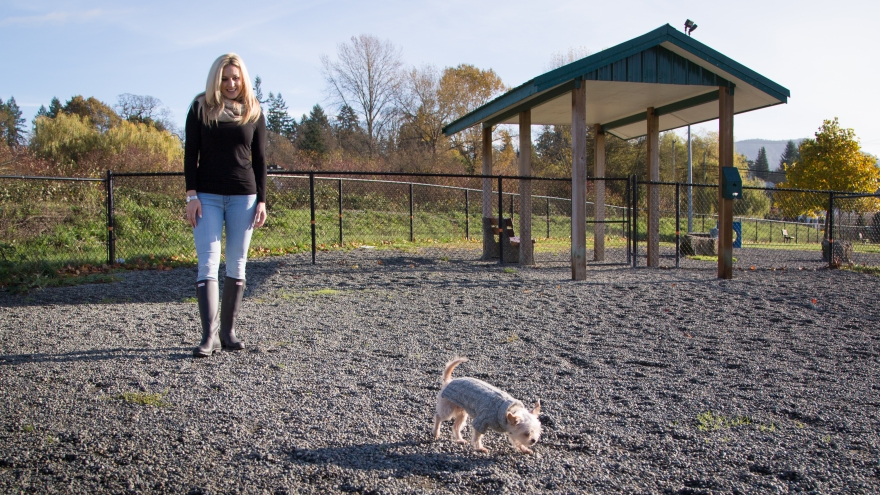 Woman with small dog next to shelter