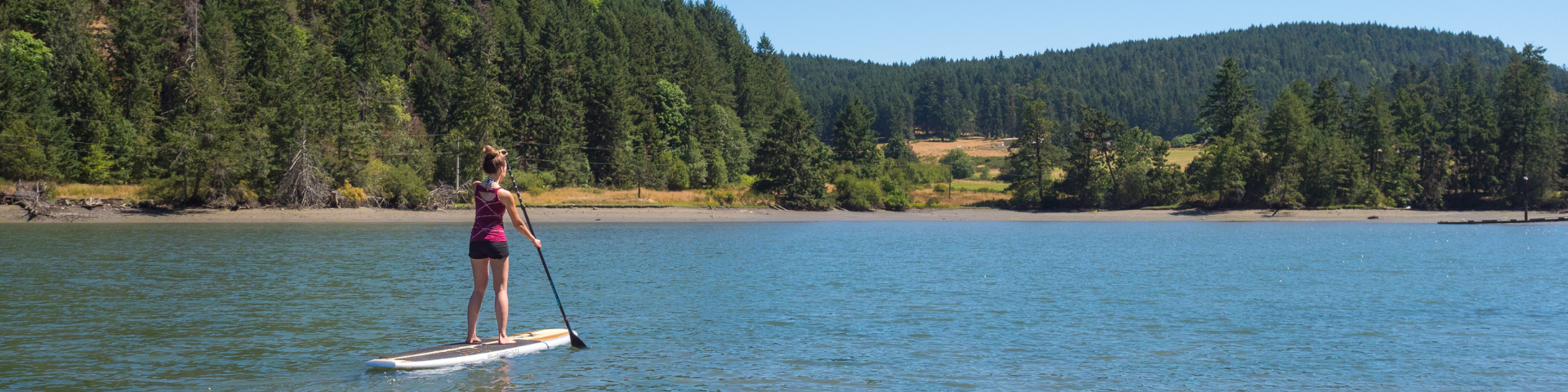 Paddle boarder standing on paddle near Maple Bay
