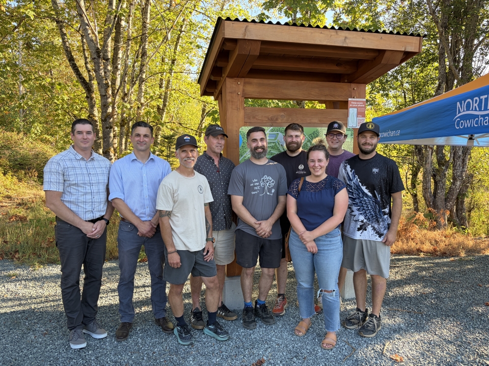 Members of staff and council pose with Cowichan Valley Disc Golf Boards of Directors with disc golf course kiosk in background